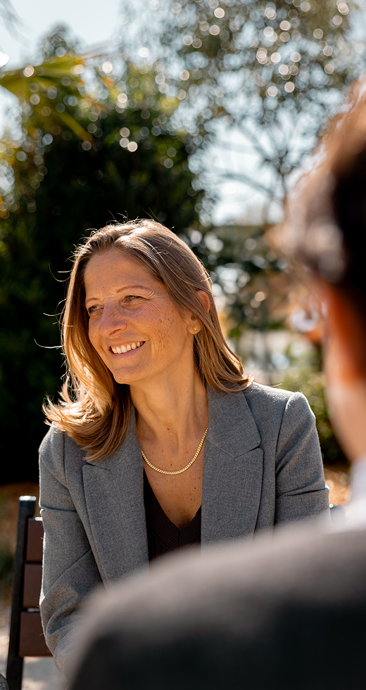 Photo de Léna souriante en pleine discussion avec une personne de dos.
