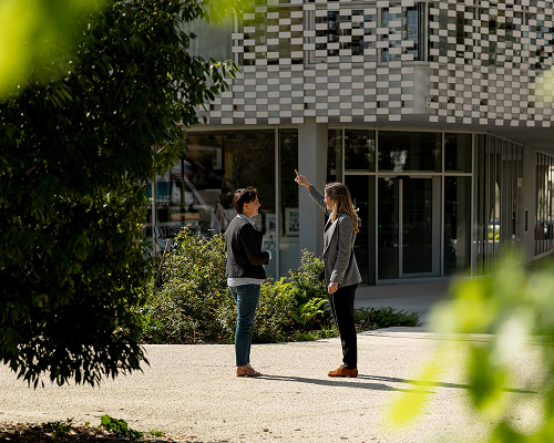 photo de Léna avec une cliente devant un bâtiment entouré de verdure.