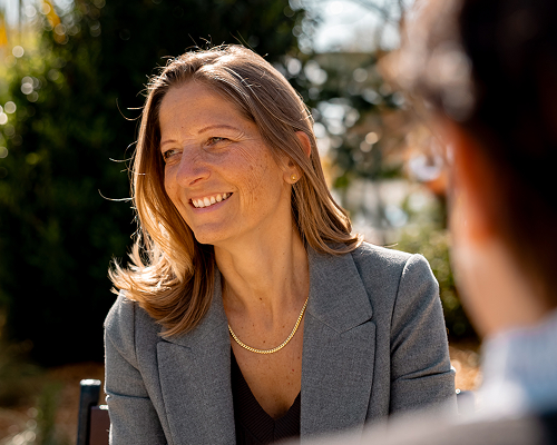 Photo de Léna souriante en pleine discussion avec une personne de dos.